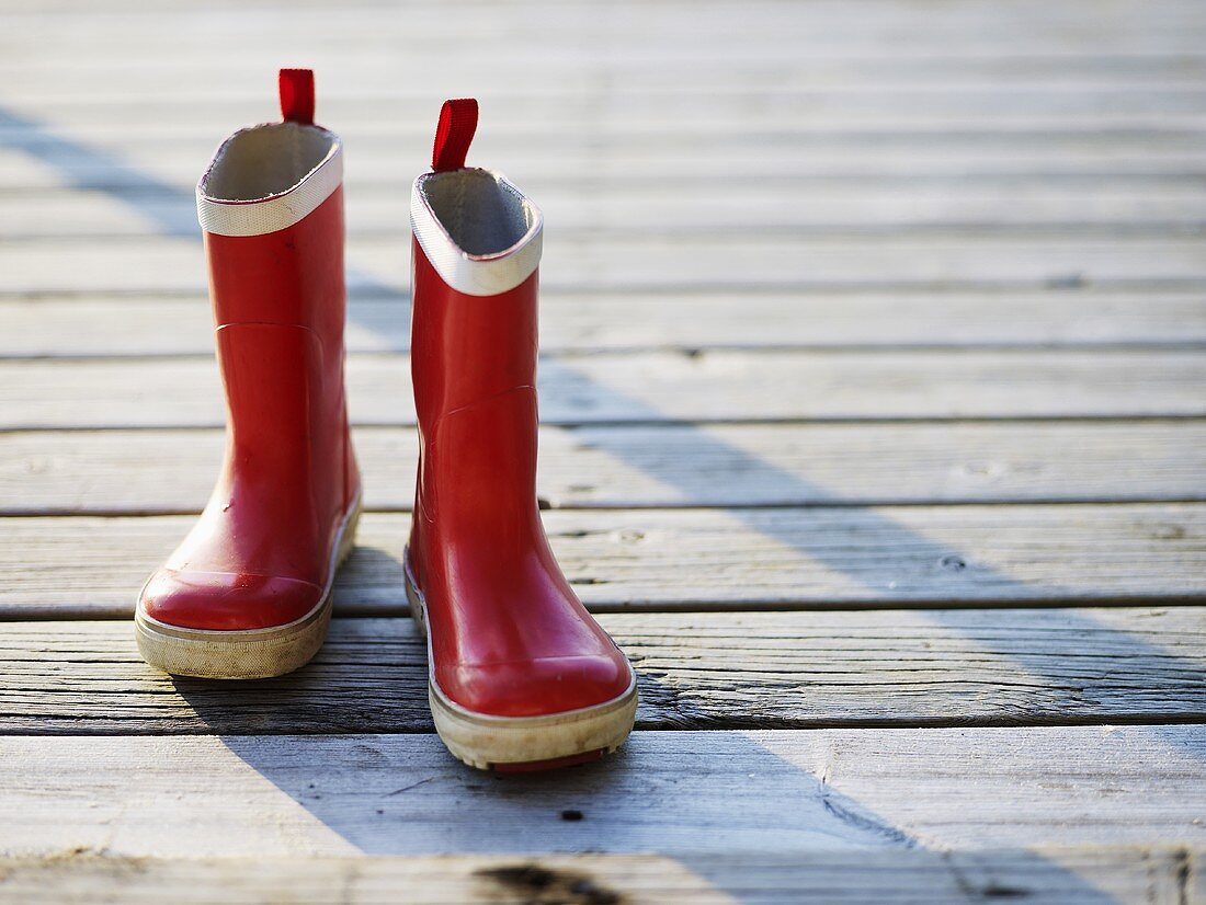 Red wellingtons on wooden landing stage
