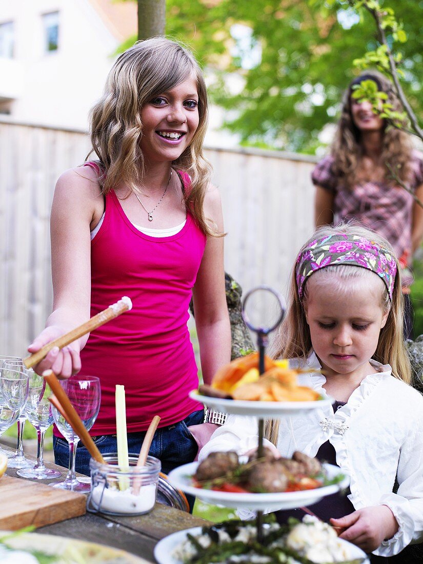Mädchen beim Smorgasbord-Buffet im Garten (Schweden)