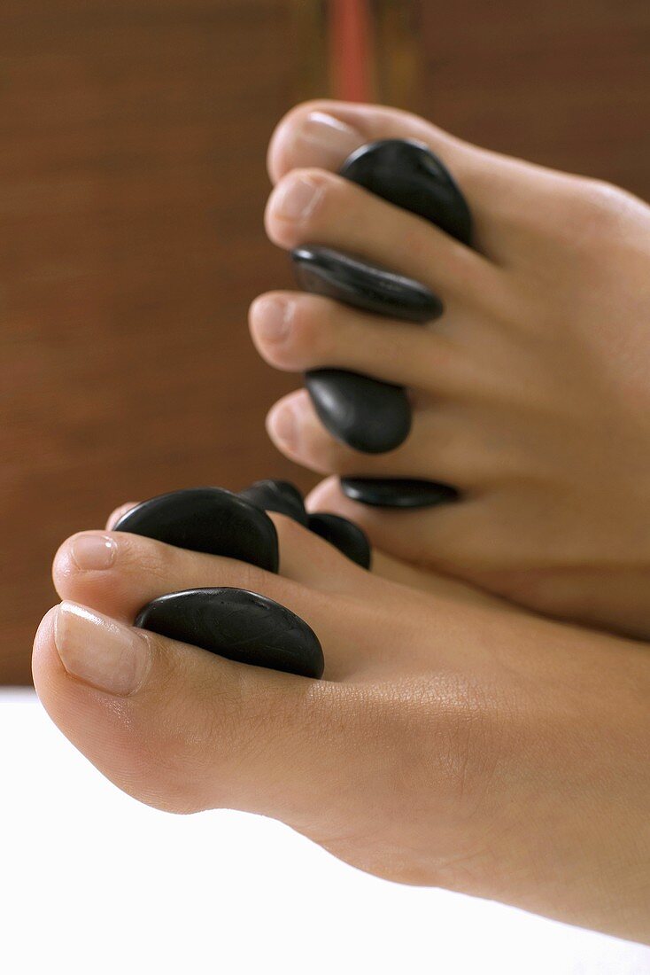 Hot stone massage: warm stones between the toes