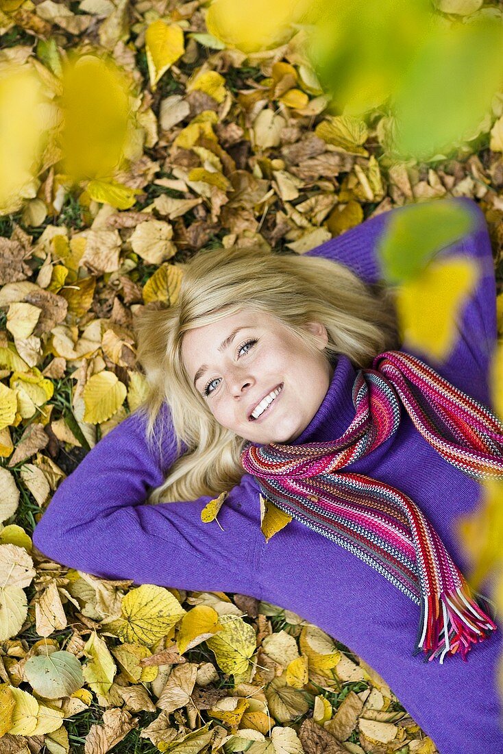 Woman lying on autumn leaves
