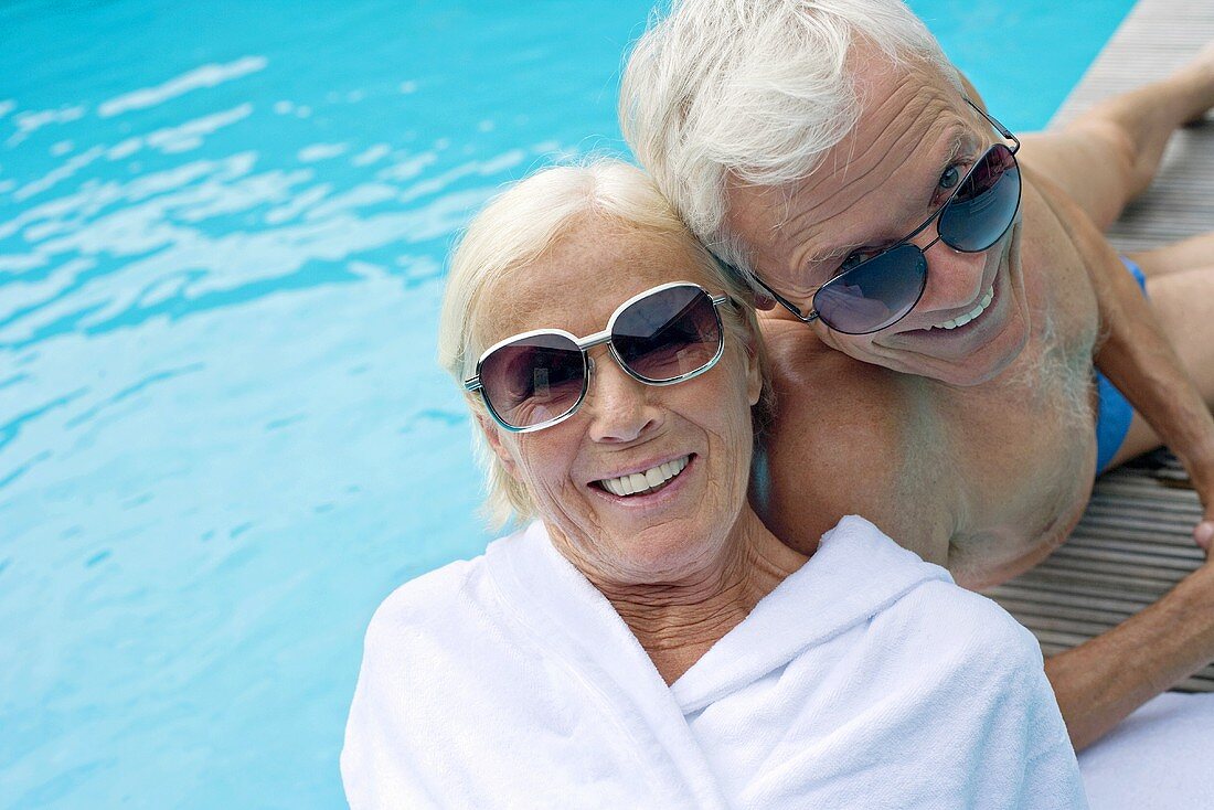 Älteres Paar auf Holzliege am Swimmingpool