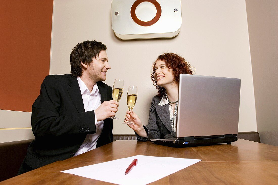 Paar trinkt Sekt im Büro