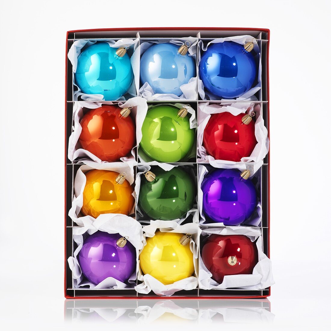 Several shiny, coloured Christmas baubles in box