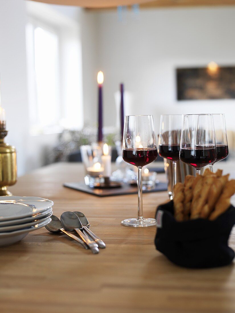 Laid table with glasses of red wine and grissini