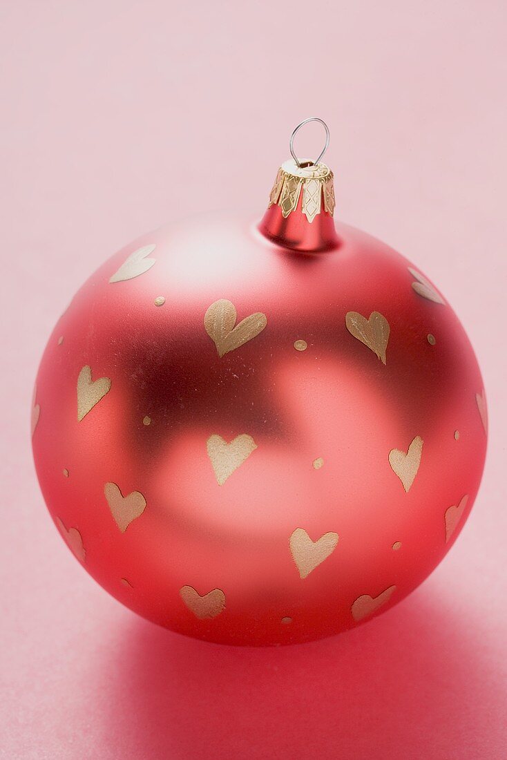 Red Christmas bauble with painted hearts