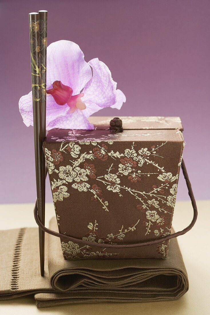Asiatischer Behälter, Orchidee und Essstäbchen
