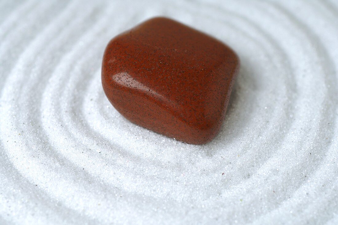 Healing stone on white sand