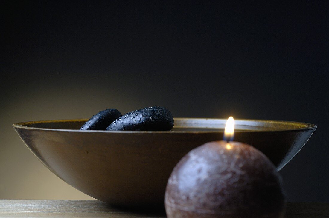Healing stones in wooden bowl, candle