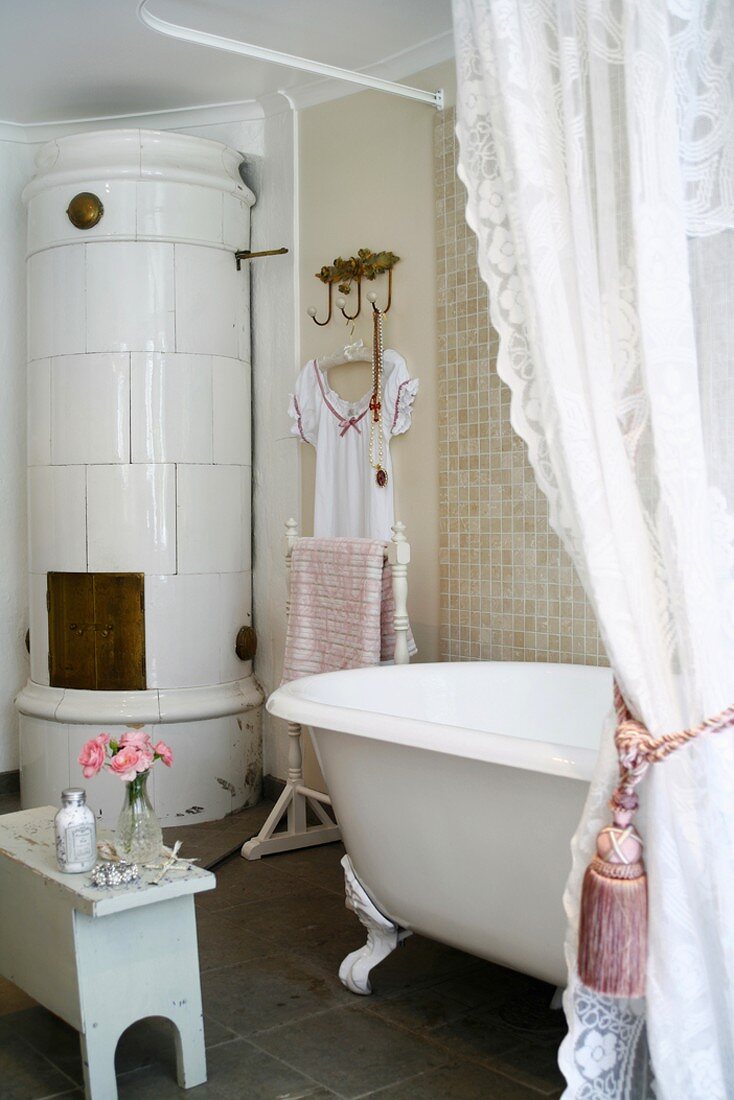 Badezimmer im traditionellen Stil mit antiker, freistehender Badewanne und einem runden Kachelofen