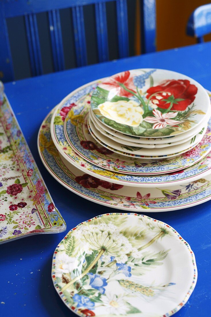 Flower-patterned plates on blue table