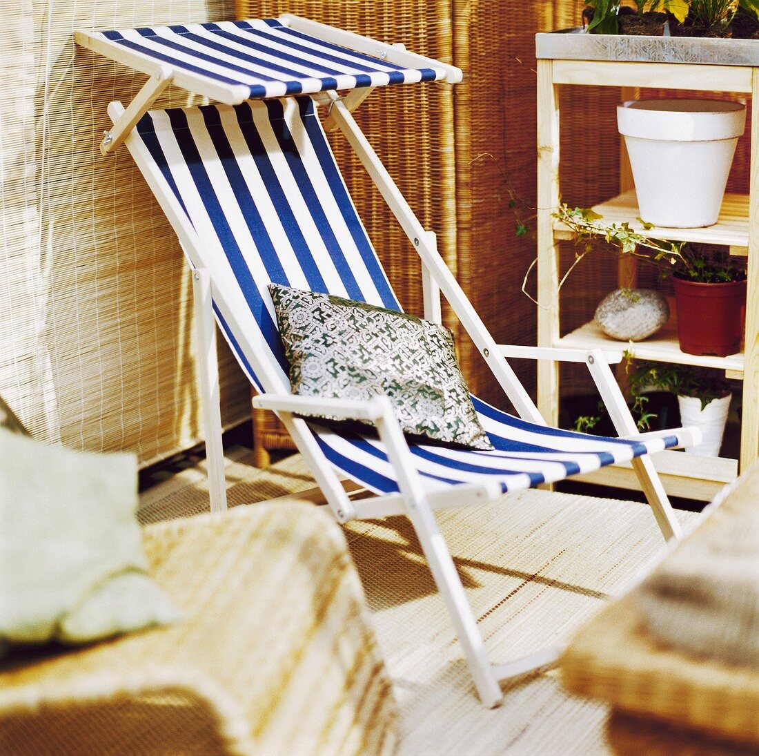 Weiß-blau gestreifte Liegestuhl auf einer Terrasse