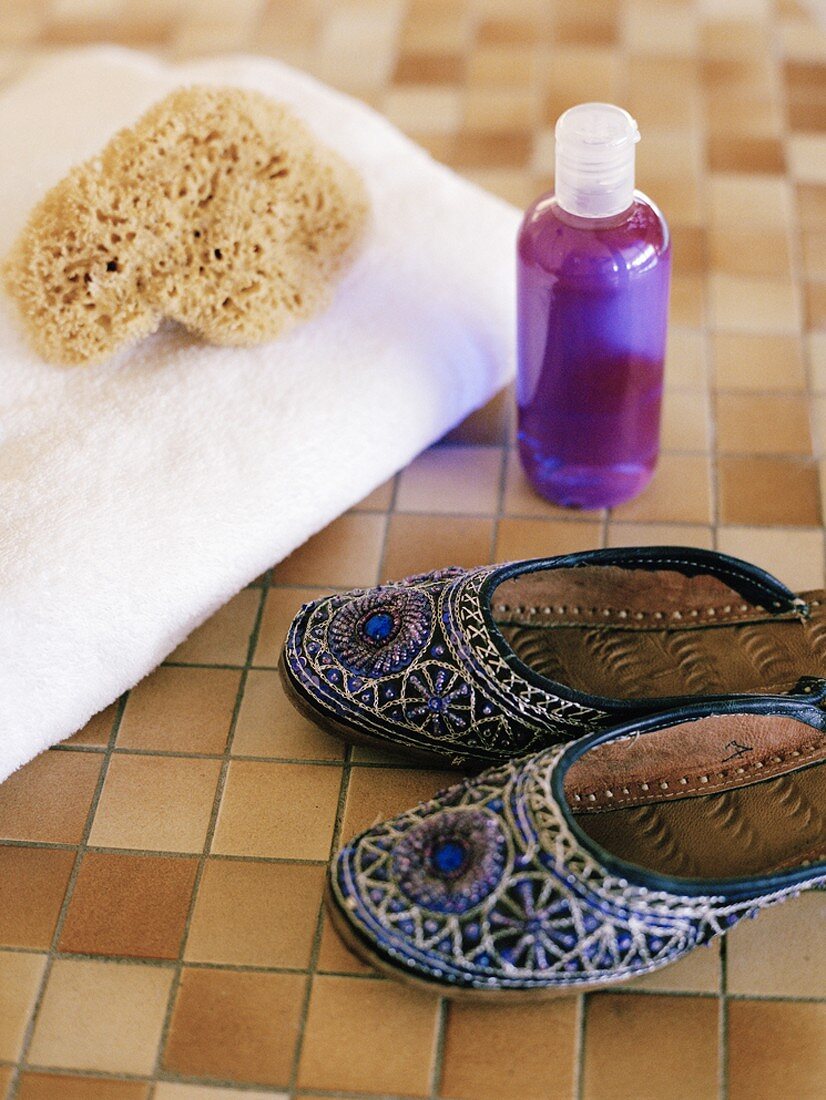 Woman's slippers, towel, sponge and small bottle