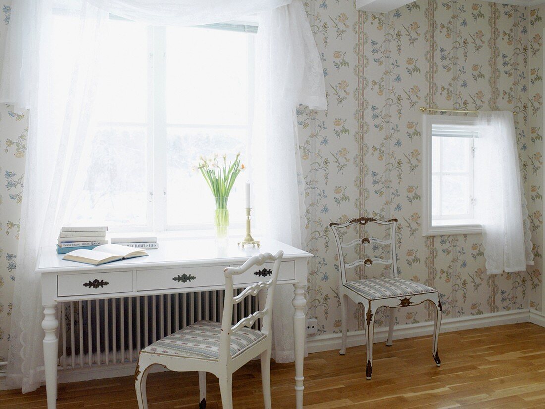 Feminines Zimmer mit weißem Schreibtisch unter dem Fenster und Blümchentapete an den Wänden