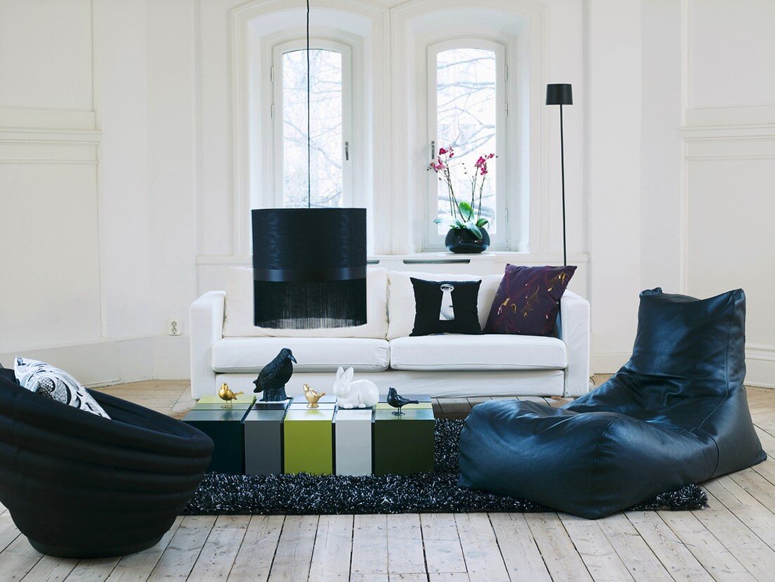 Modernes Wohnzimmer in schwedischem Haus mit gemütlichen Sitzmöbeln und rechteckigem, mehrfarbigem Couchtisch