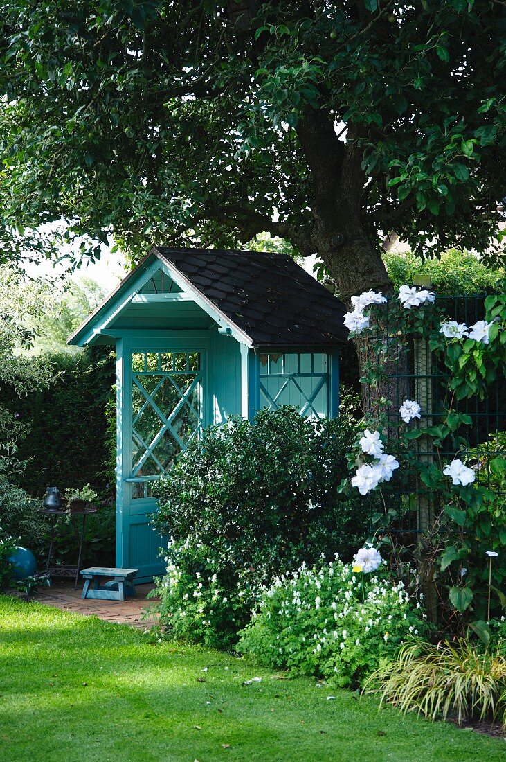 A blue arbour seat in a garden