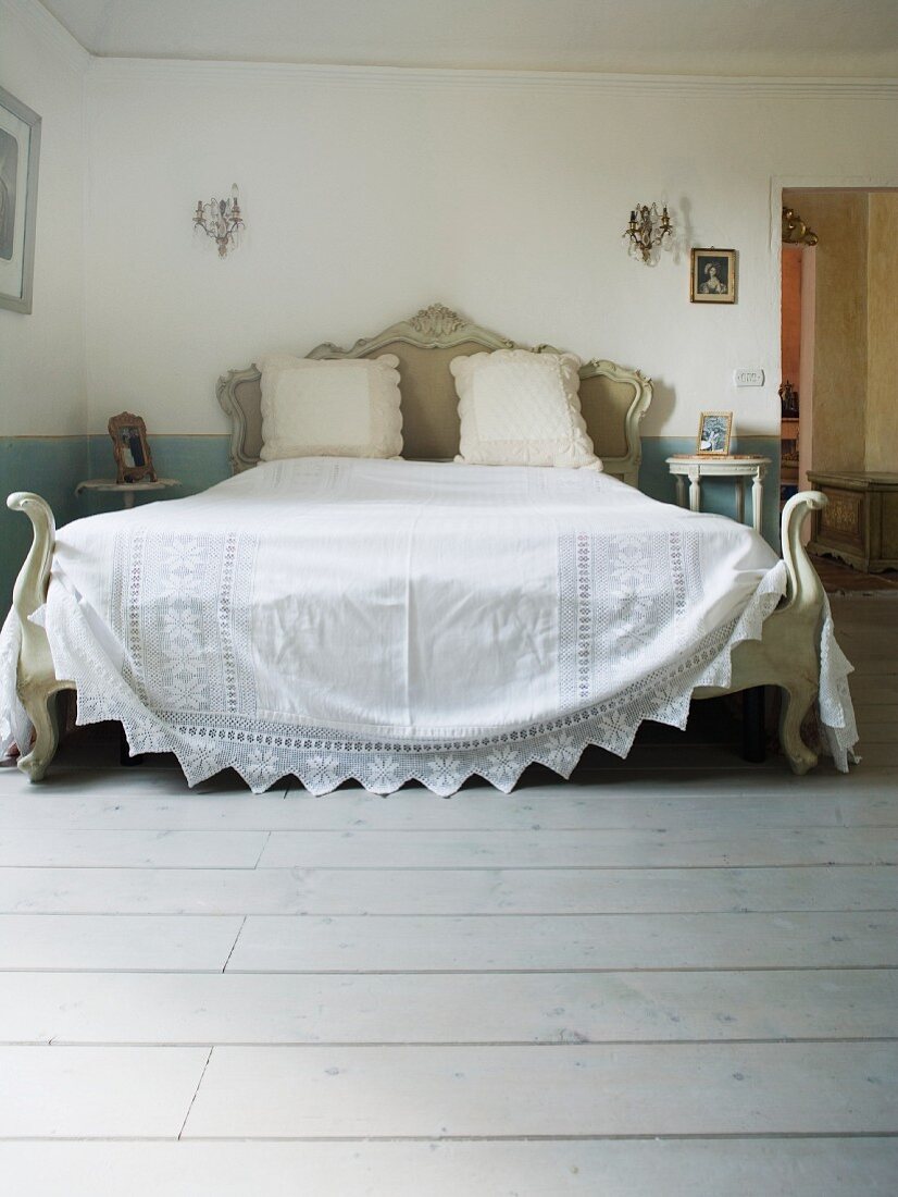 Antikes Doppelbett mit weisser Tagesdecke in einem toskanischen Landhaus