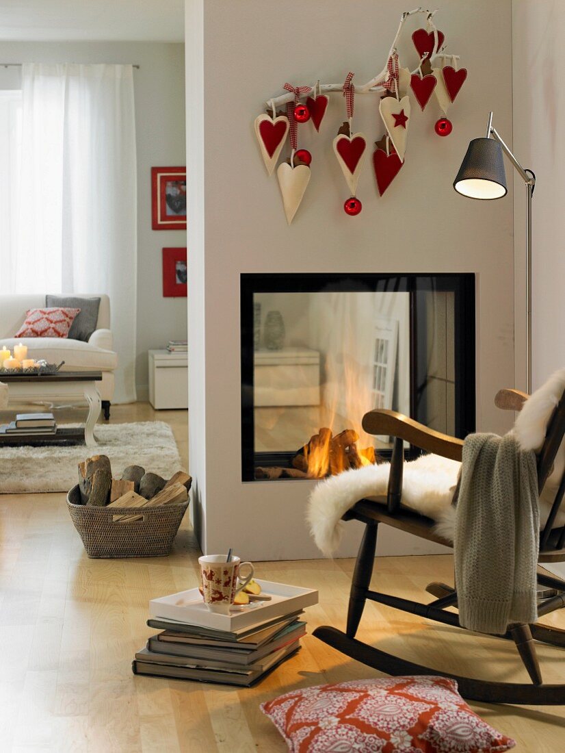 Homemade heart-shaped felt bags hanging from a twig above and open fire place