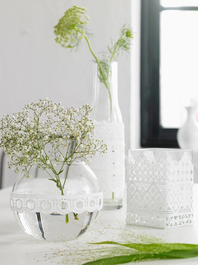 Glass vases and bottles decorated with lace trim