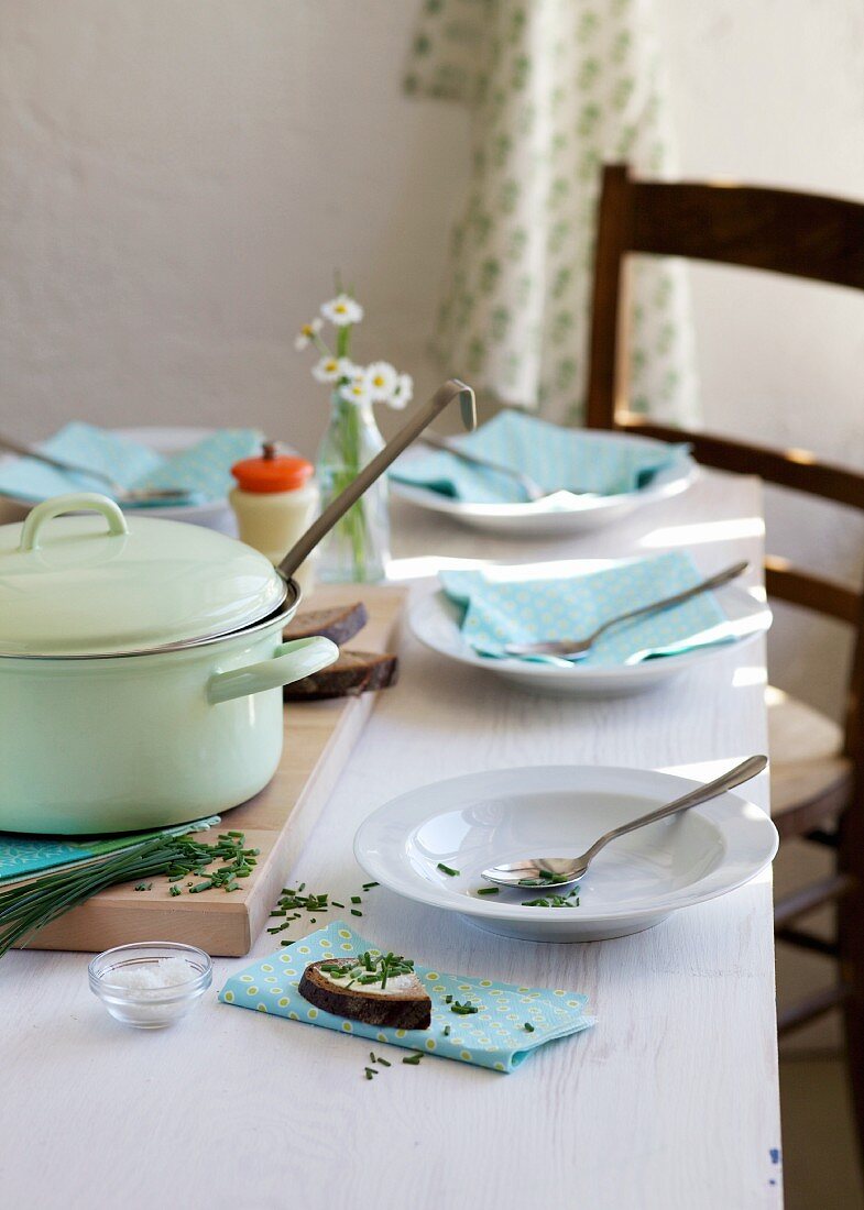 Gedecker Tisch mit Suppentellern, Suppentopf & Schnittlauchbrot