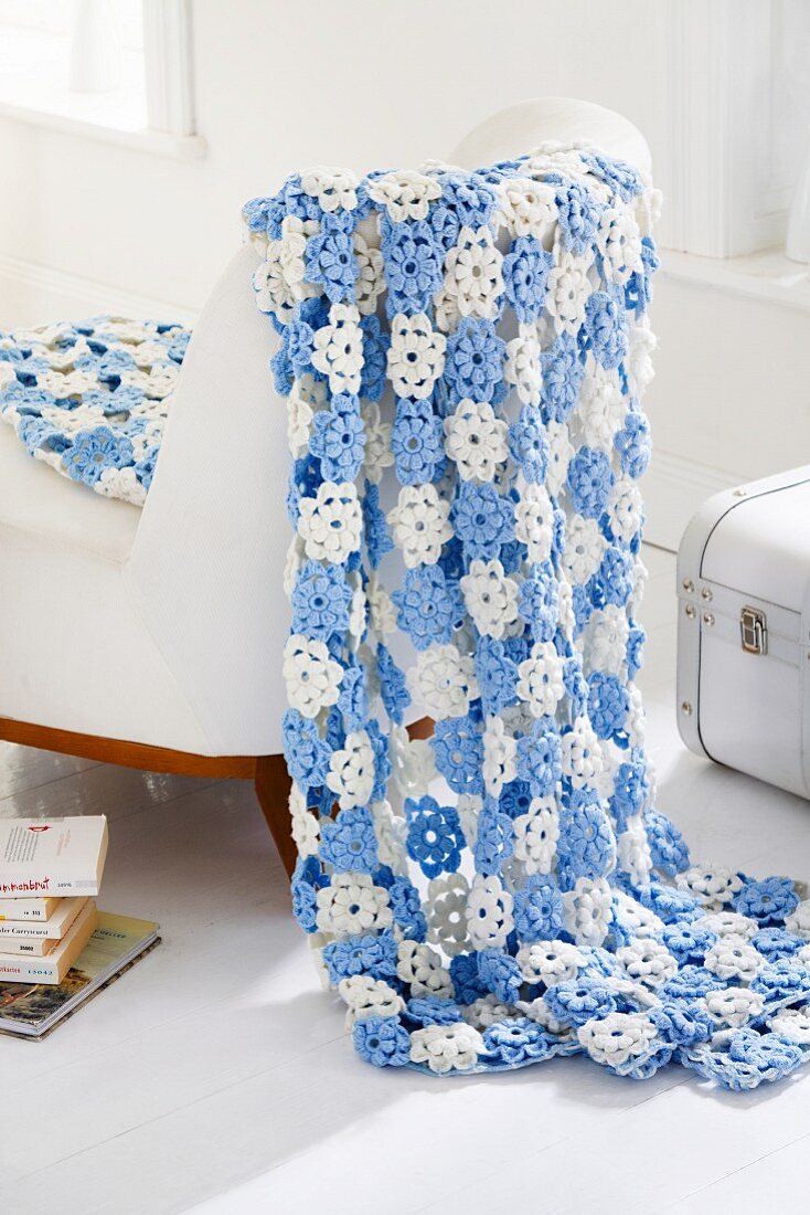 Blue and white blanket of crocheted flowers