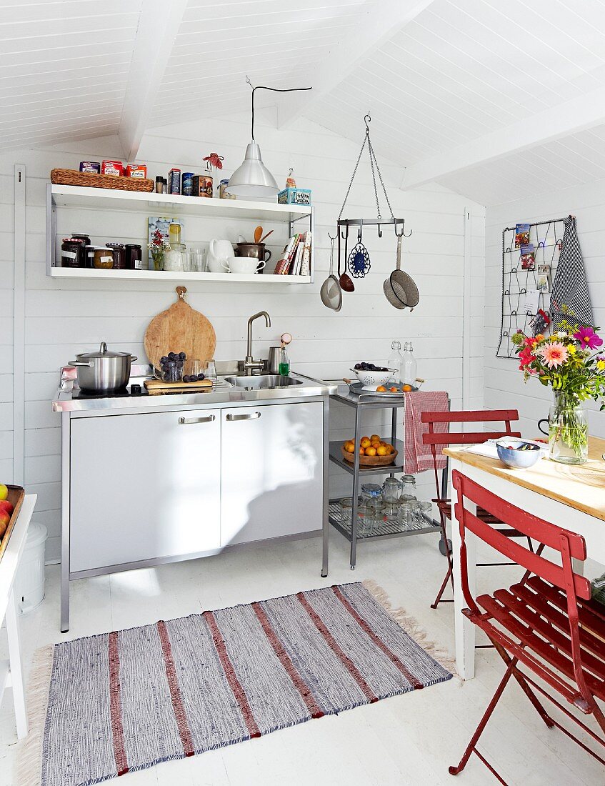 Weisses Gartenhaus aus Holz im skandinavischen Stil mit Kochbereich