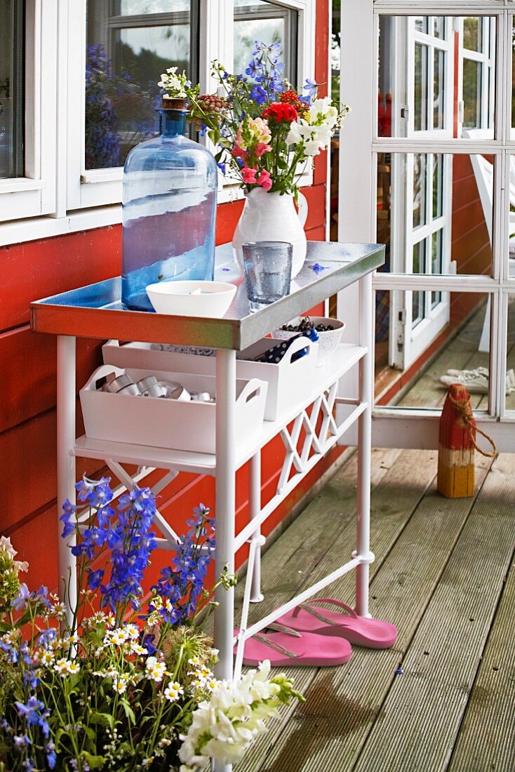 A wall table outside a red-painted holiday house