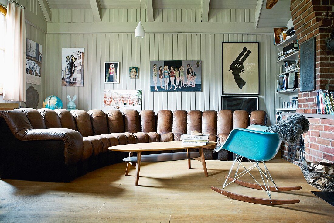 Wohnzimmer in Landhaus mit Wandvertäfelung & grossem bogenförmigen Sofa