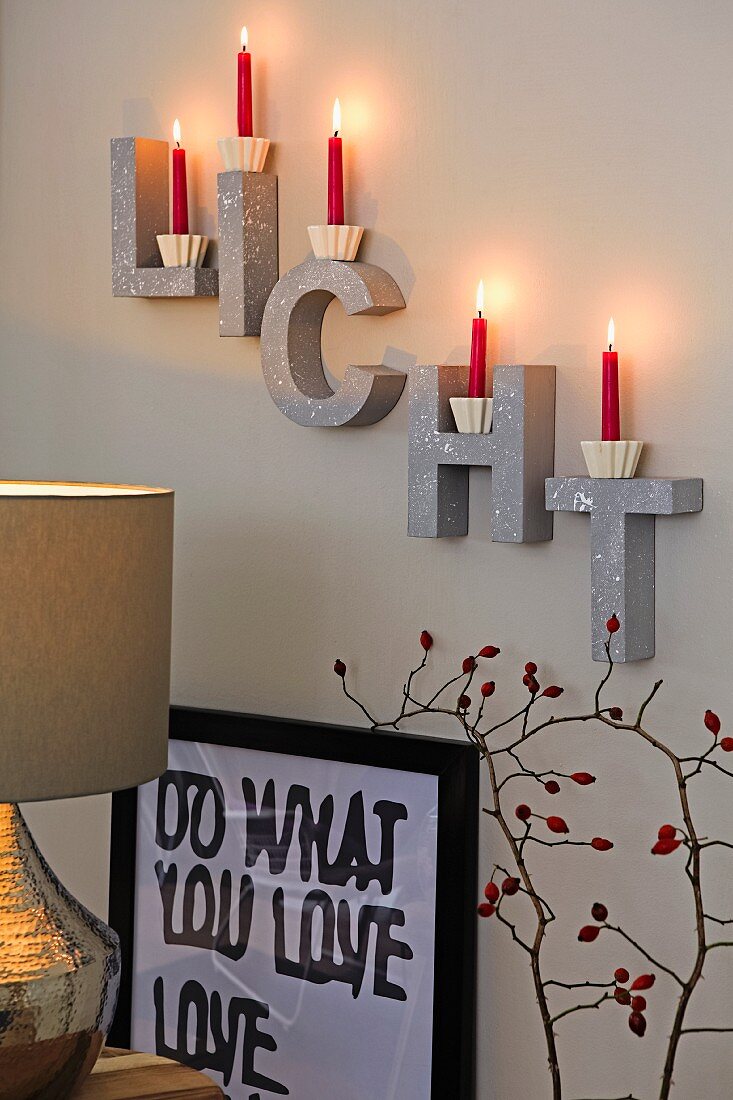 Red candles on decorative letters on a wall