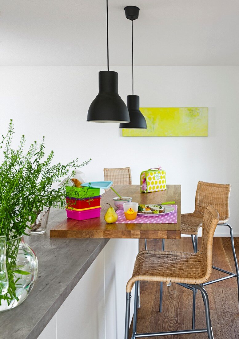 A seating area with bar stool and a pendant lamp at a modern kitchen island