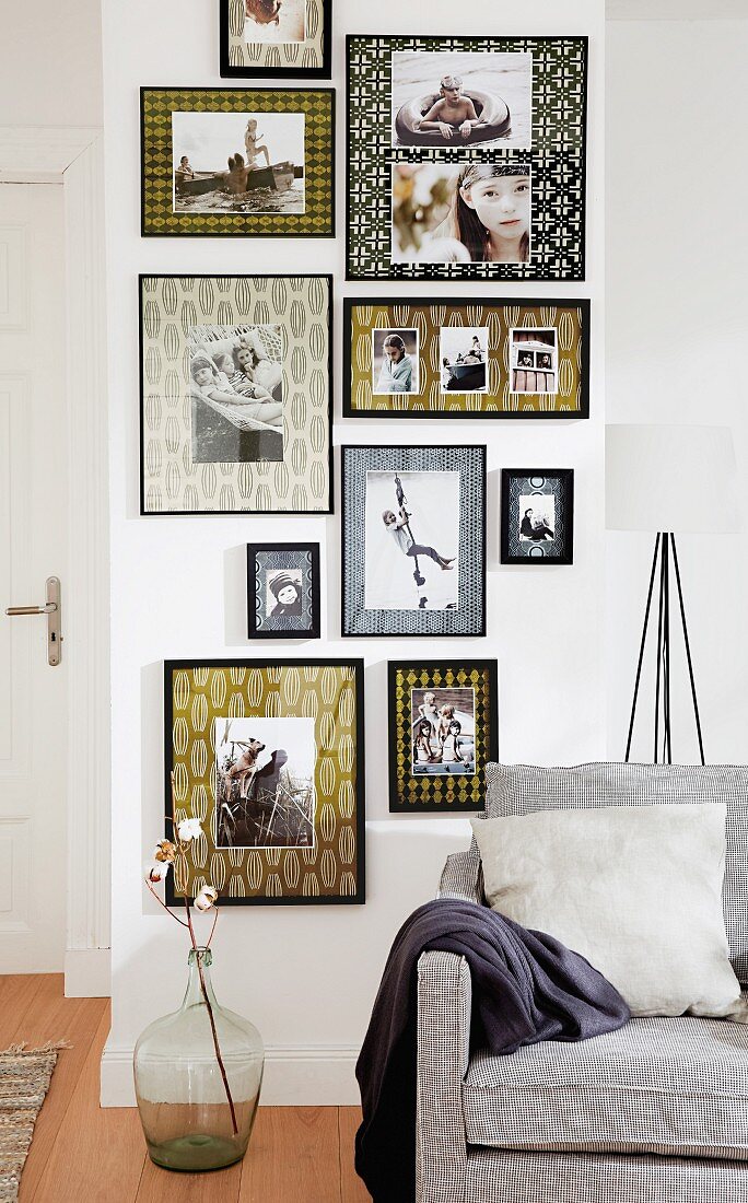 Wohnraum mit Sofa & dekorativer Bildergalerie an Zimmerwand