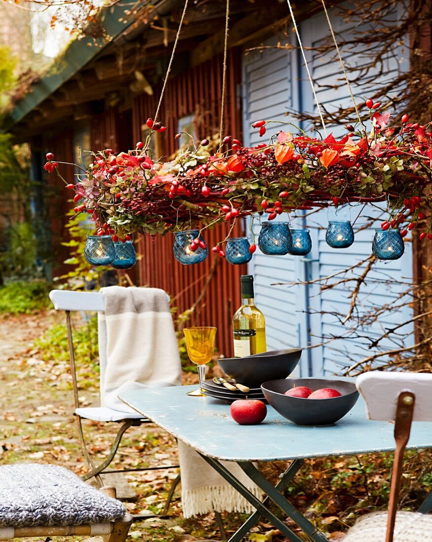 Garden table decorated with autumnal wreath & tealight lanterns