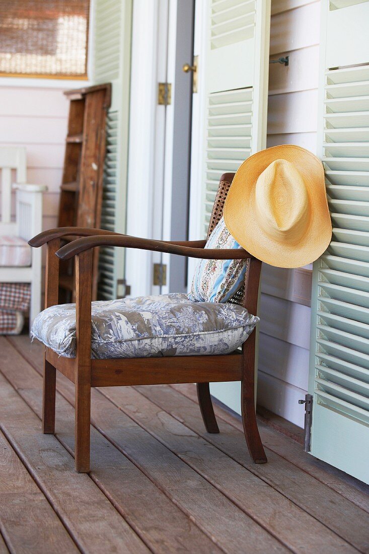 Holzstuhl mit Armlehnen & Sitzkissen auf Veranda