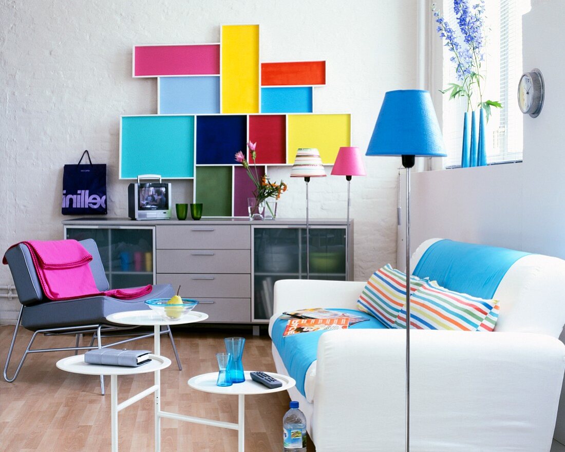 Moderner Wohnraum mit Sofa, Sideboard und farbigen Paneelen an Wand
