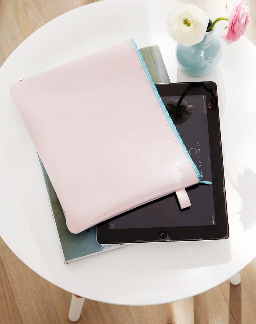 Tablet-PC mit selbst genähter Ziegenleder-Hülle und Ranunkelblüten auf Beistelltisch