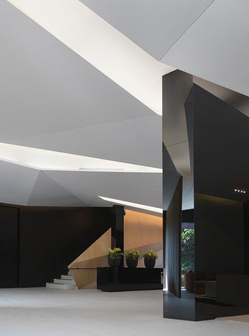 Eingangshalle mit gefaltetem Deckenelementen und dreidimensionalen Wänden mit polierten schwarzen Steinfliesen