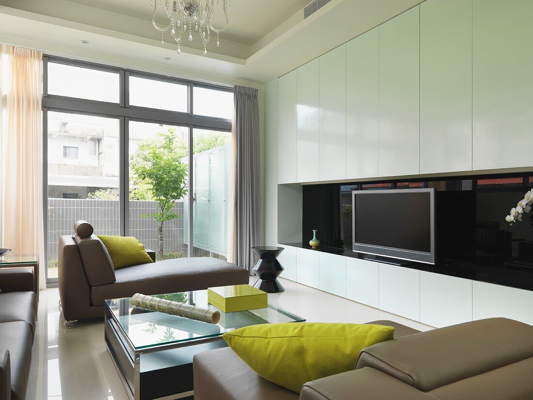 Designer Wohnzimmer mit Polsterliegen vor weißem Einbauschrank und Terrassenfenster