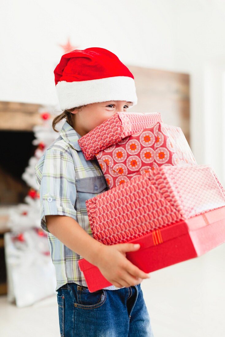 Boy in Santa hat with Christmas gifts