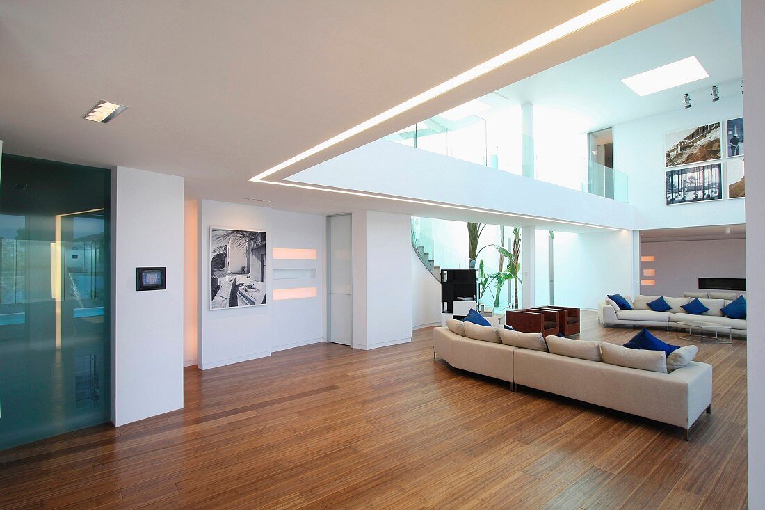 Sofagarnitur auf Holzfussboden in offenem Designer Wohnraum und Blick auf Galerie