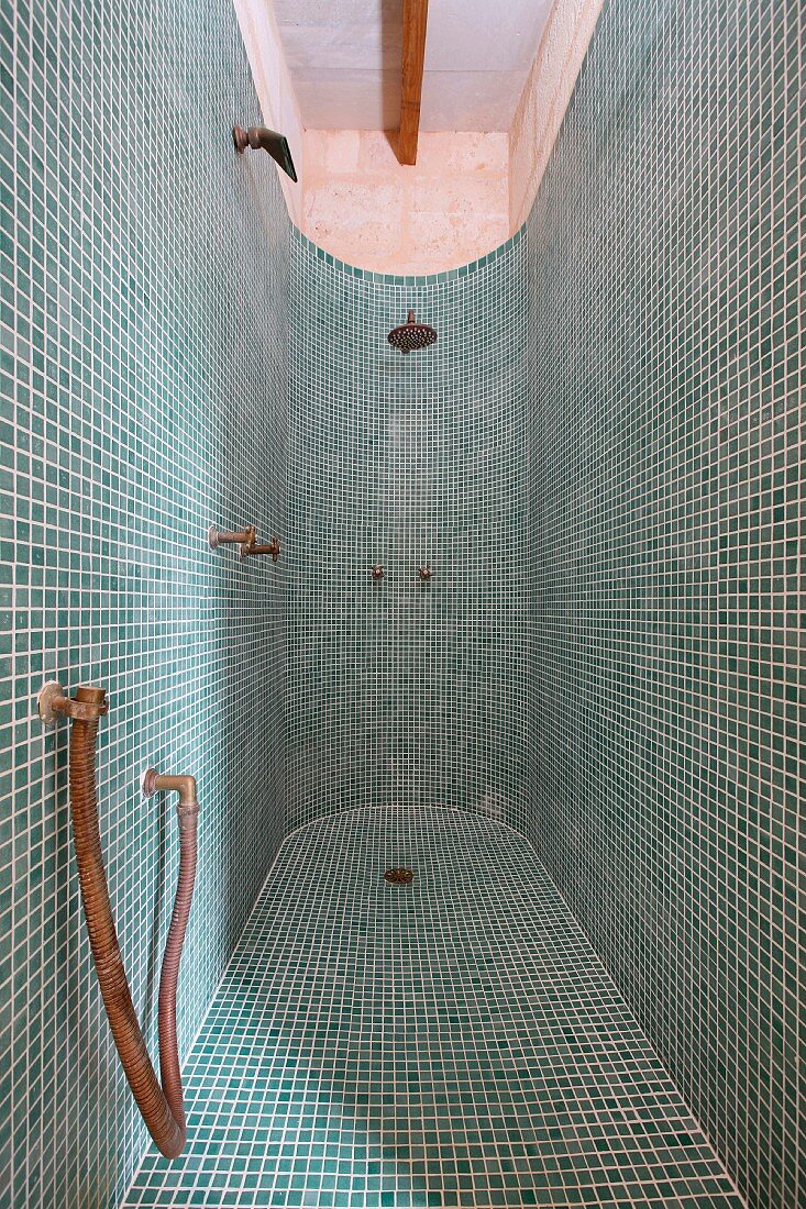 Duschbereich mit abgerundeter Wand und grünen Mosaikfliesen