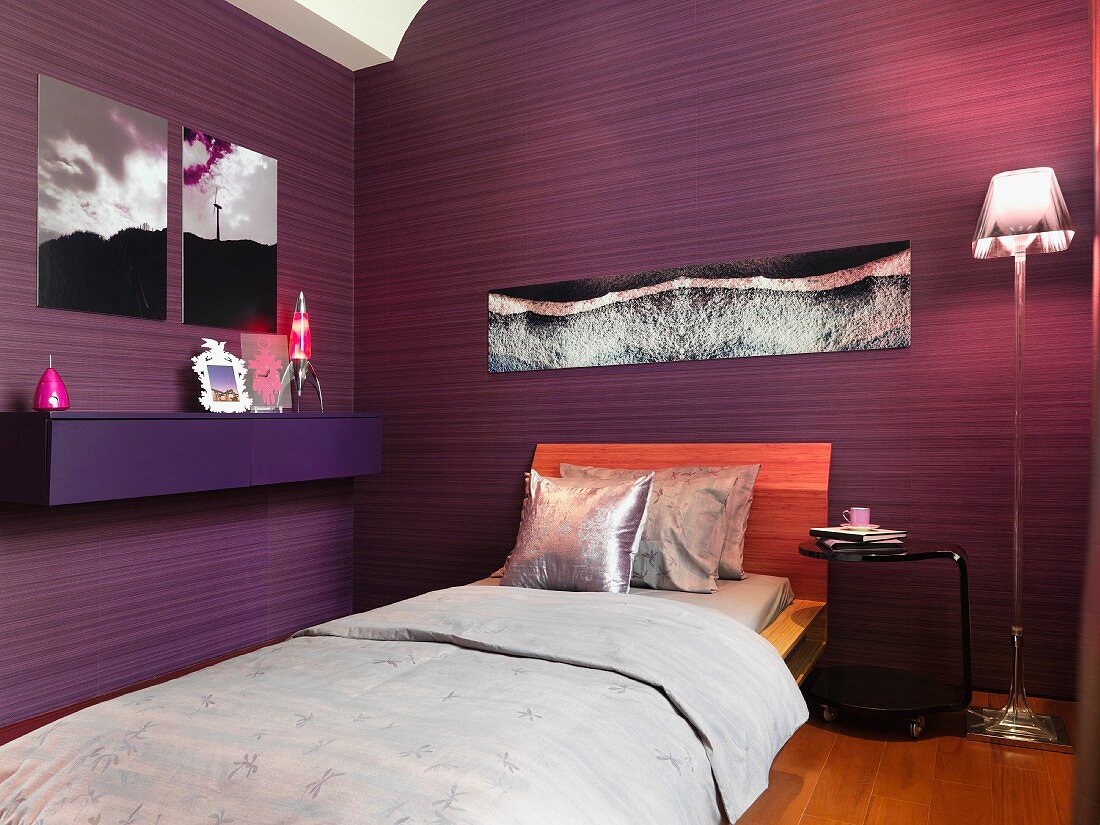 Schlafzimmer mit dunkelviolett gestreifter Tapete und silbergrauer Bettwäsche