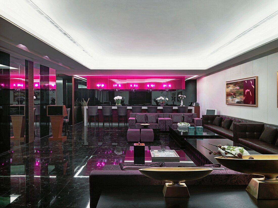 Classic modern lounge in dark shades with hot pink light installations and Oriental-style decorations