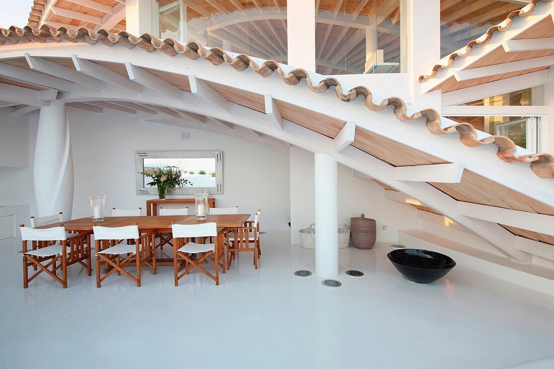 Holztisch und Stühle mit Segeltuchbezug im modernen Wohnhaus