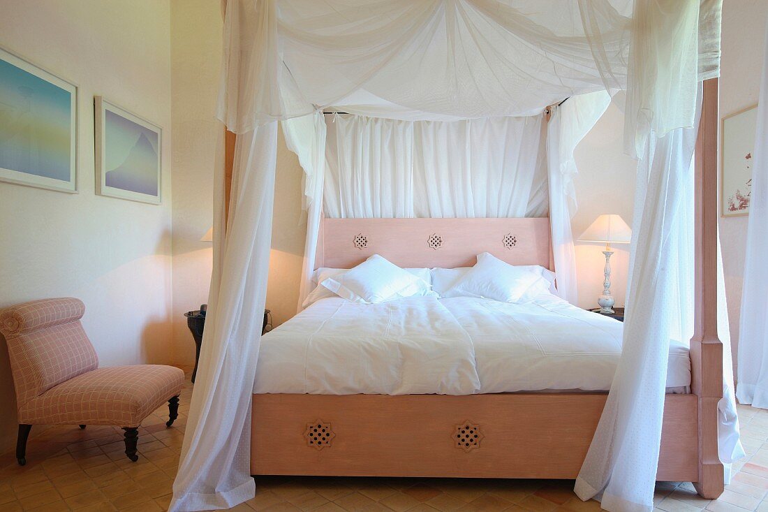 Himmelbett mit Baldachin aus weißem Stoff und rosafarbenes Holzgestell