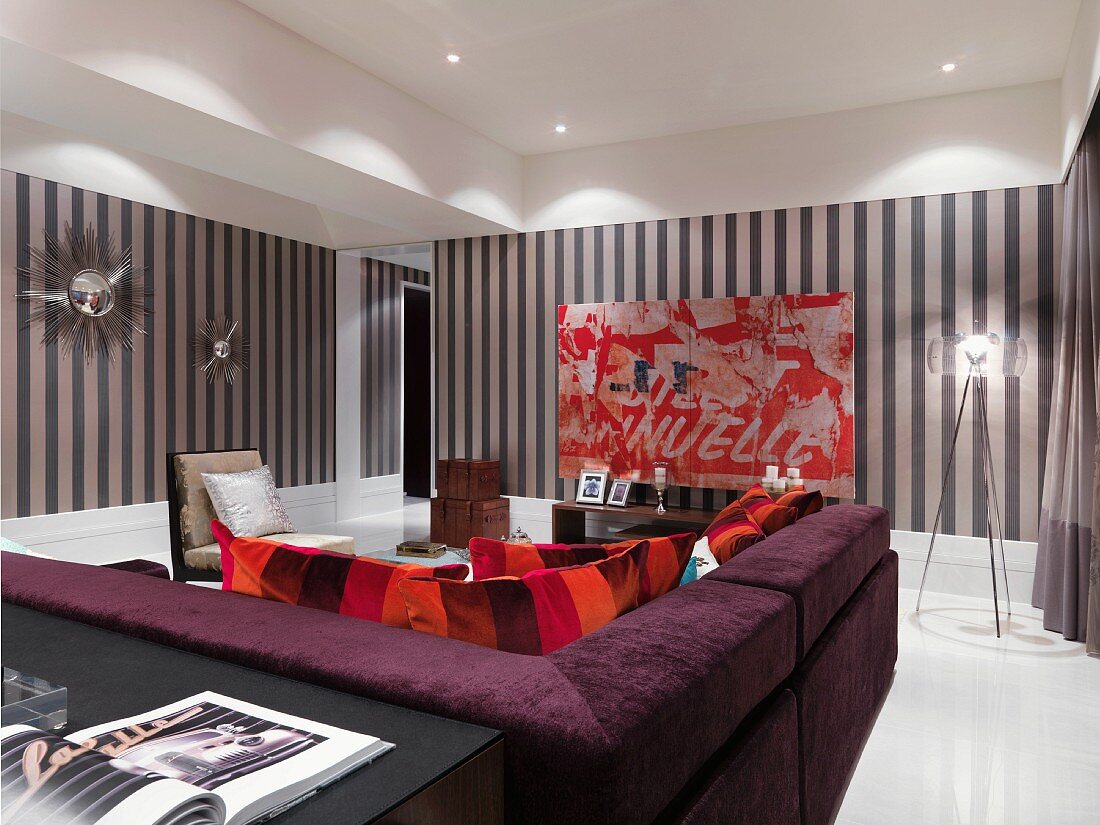 Violette Polstercouch im modernen Wohnzimmer mit gestreifter Tapete an Wand