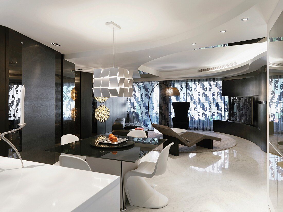 Zeitgenössischer Wohnraum mit Esstisch und weissen Schalenstühlen auf weißem hochglänzendem Boden und beleuchteter Wand