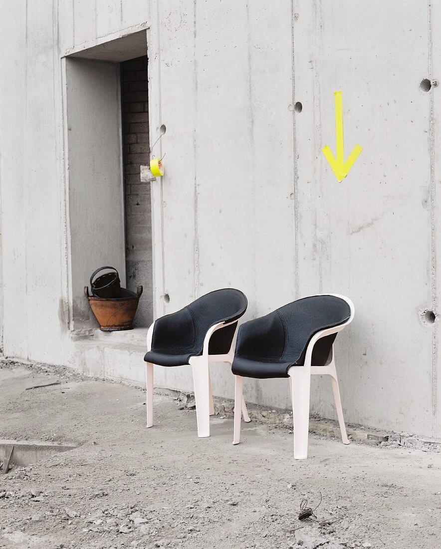 Vintage shell chairs with leather covers against concrete wall