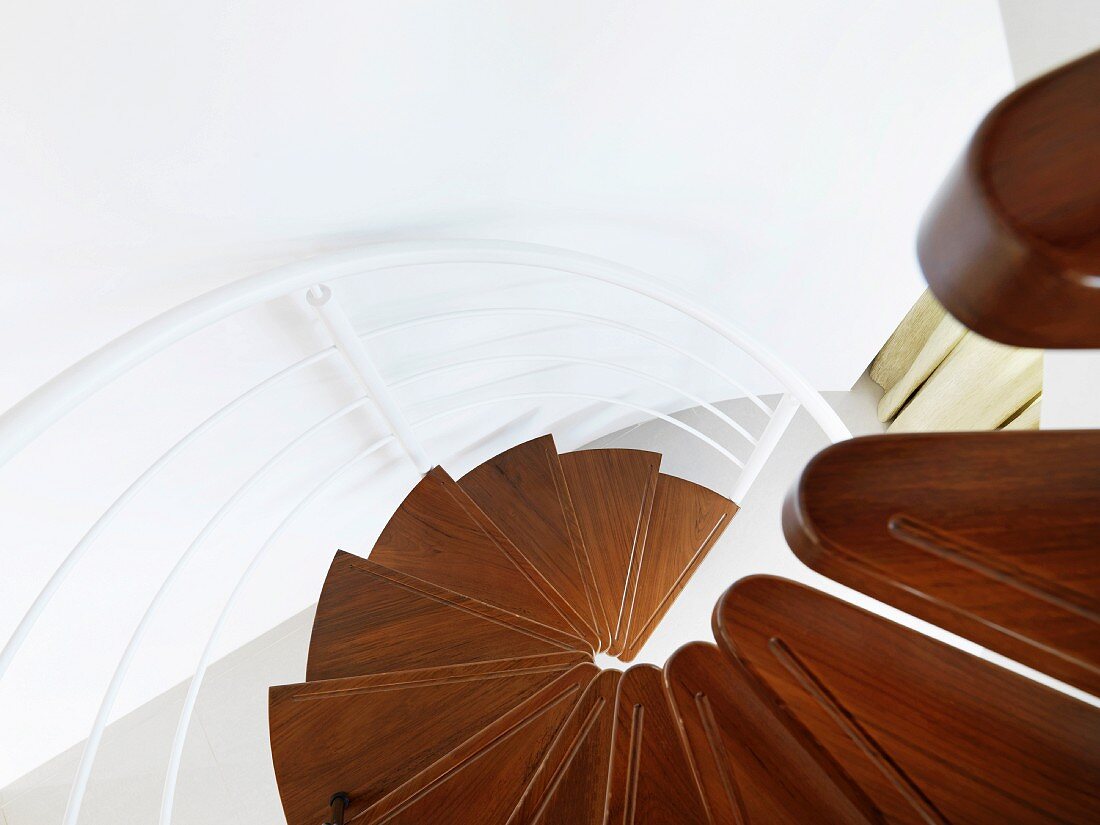 View of a modern circular staircase with wood treads and white metal bannister