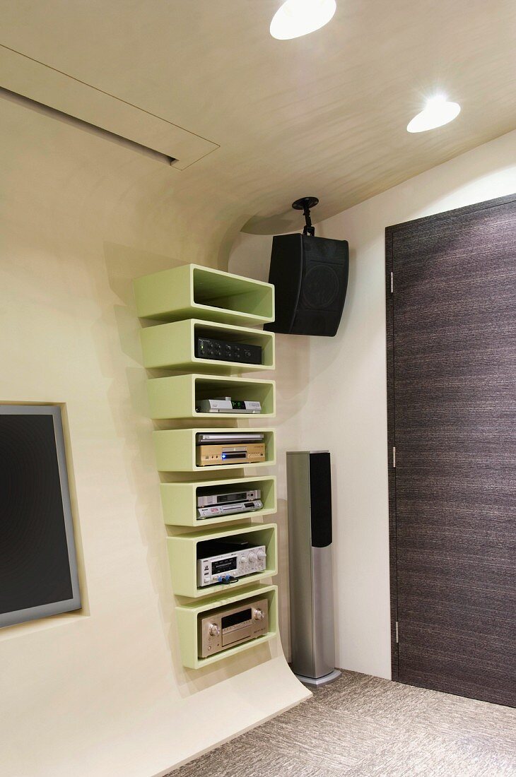 Futuristischer Wohnraum mit Vorsatzschale aus Beton mit abgerundeten Kanten und integriertem Regal neben TV