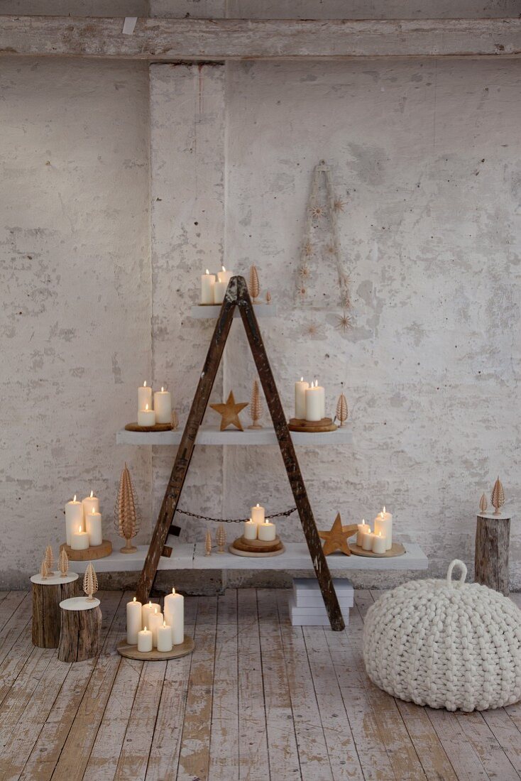 Selbstgebautes Regal mit brennenden Kerzen auf weissen Regalböden in rustikalem Ambiente