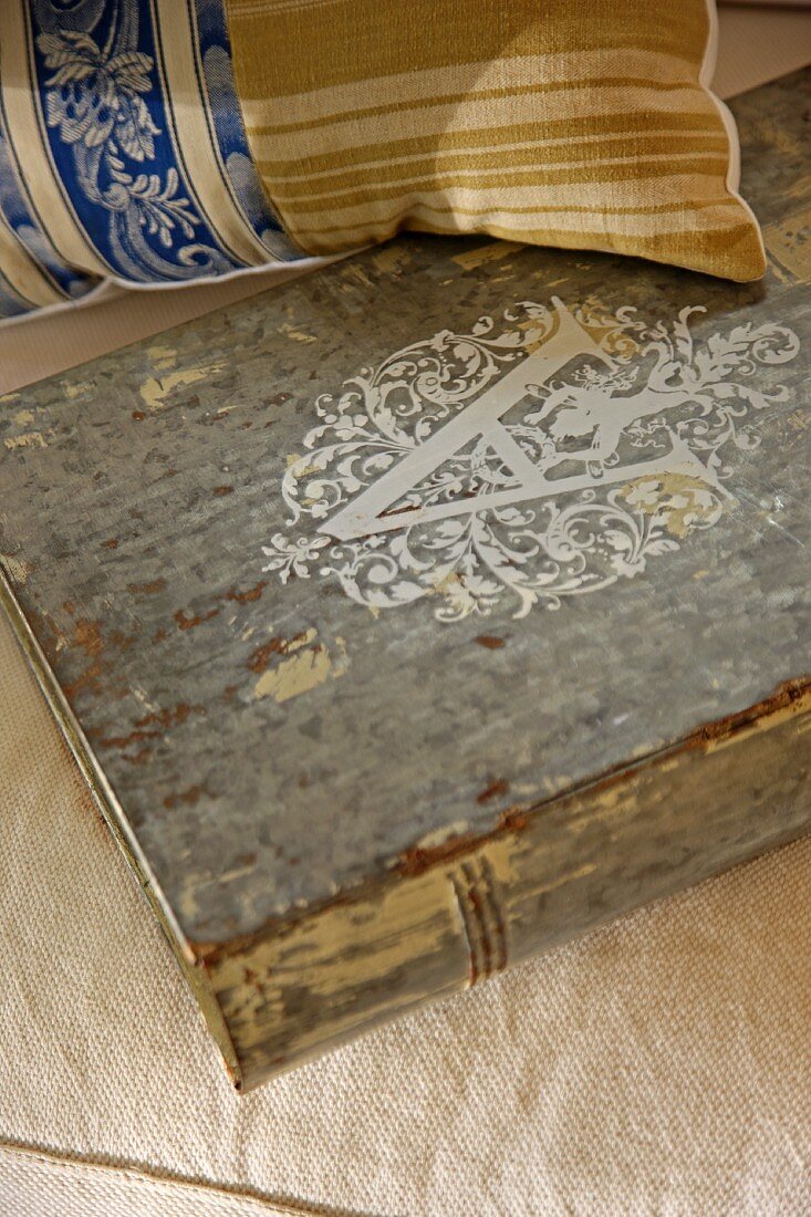 Antiquarisches Buch und Vintage Kissen auf Polster